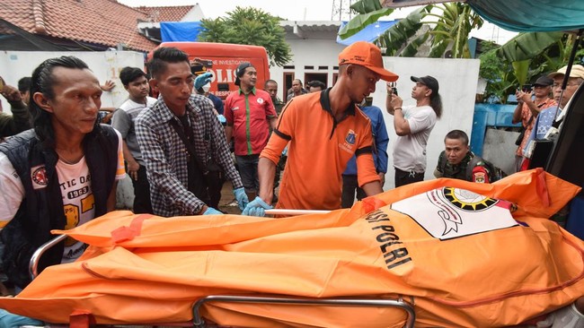 Petugas mengevakuasi jenazah korban dalam kasus kematian satu keluarga di kawasan Warakas, Tanjung Priok, Jakarta Utara, untuk proses penyelidikan lebih lanjut.