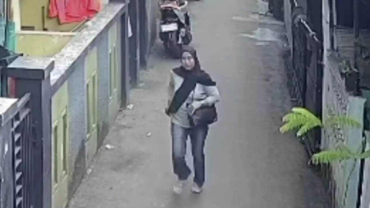 Seorang wanita yang diduga mencuri uang takziah terekam kamera pengawas saat berjalan meninggalkan lokasi di kawasan Kramat Jati, Jakarta Timur.