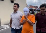 Tersangka EM (53) berjalan dengan pengawalan petugas Satreskrim Polres Mojokerto Kota saat ditunjukkan kepada awak media. Pria tersebut ditangkap atas dugaan kasus kekerasan seksual terhadap anak tirinya.