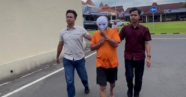 Tersangka EM (53) berjalan dengan pengawalan petugas Satreskrim Polres Mojokerto Kota saat ditunjukkan kepada awak media. Pria tersebut ditangkap atas dugaan kasus kekerasan seksual terhadap anak tirinya.