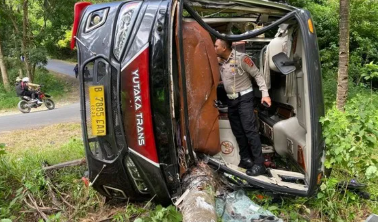 Petugas kepolisian memeriksa kondisi bus wisata yang terguling usai kecelakaan di turunan Cariang, Kabupaten Lebak, Banten, Selasa (24/3/2026) pagi.