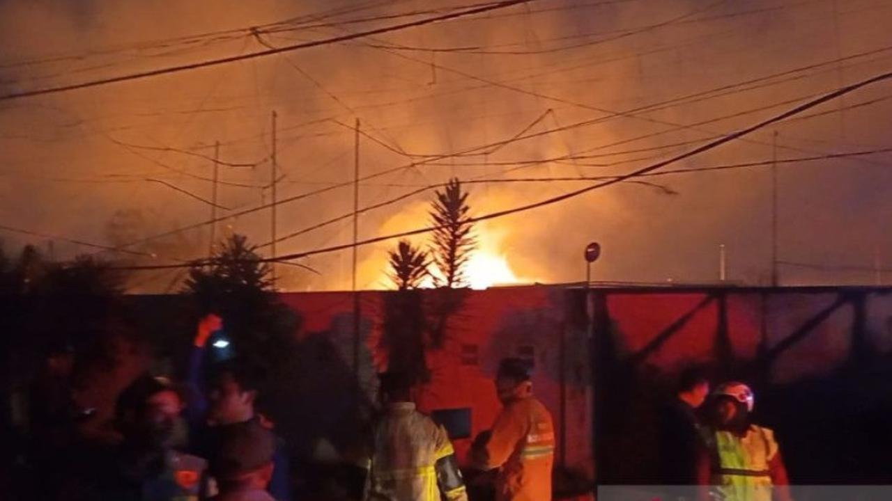 Petugas damkar bersama warga berupaya memadamkan kebakaran di SPBE Cimuning, Bekasi.