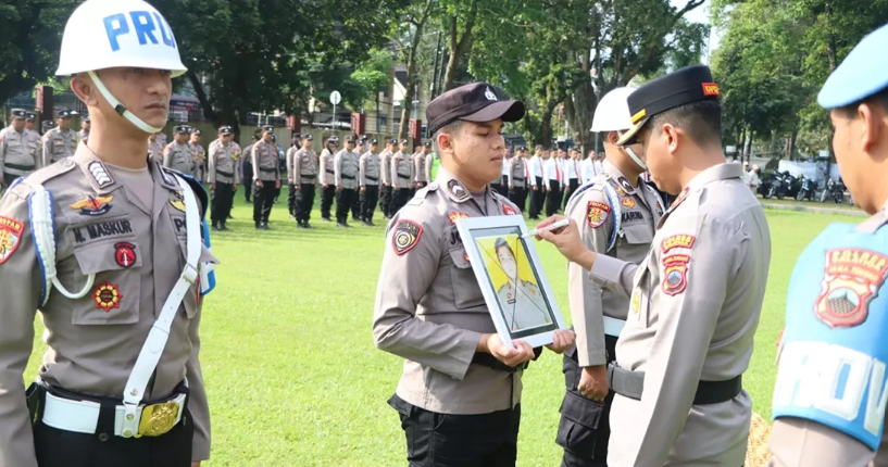 Kapolres Salatiga AKBP Ade Papa Rihi mencoret foto anggota sebagai simbol pemberhentian tidak hormat dalam upacara di Lapangan Bhayangkara.